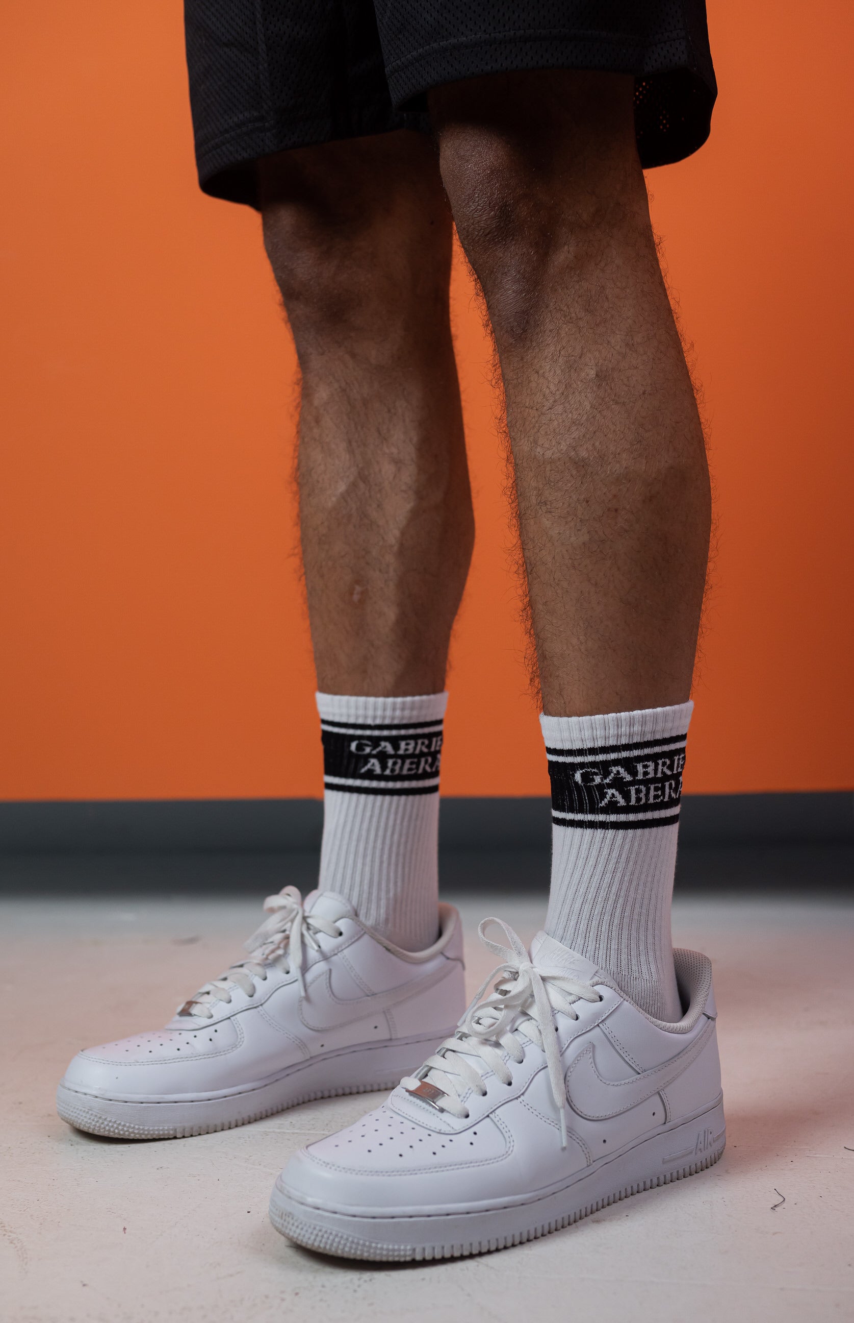 Legs of a model wearing a pair of white socks with black section and brand