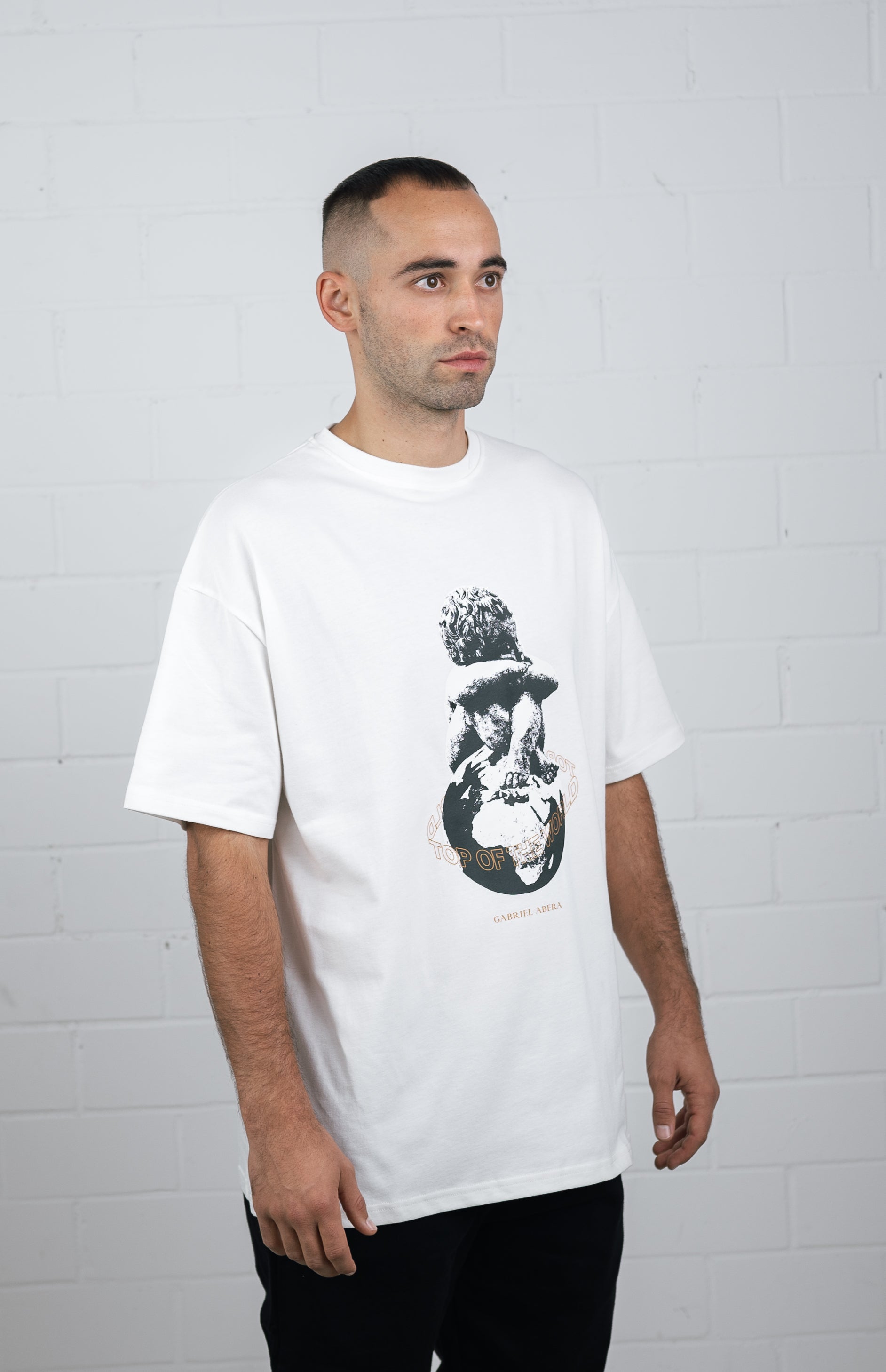 Male model wearing a White oversize t shirt with kid on globe design in the front
