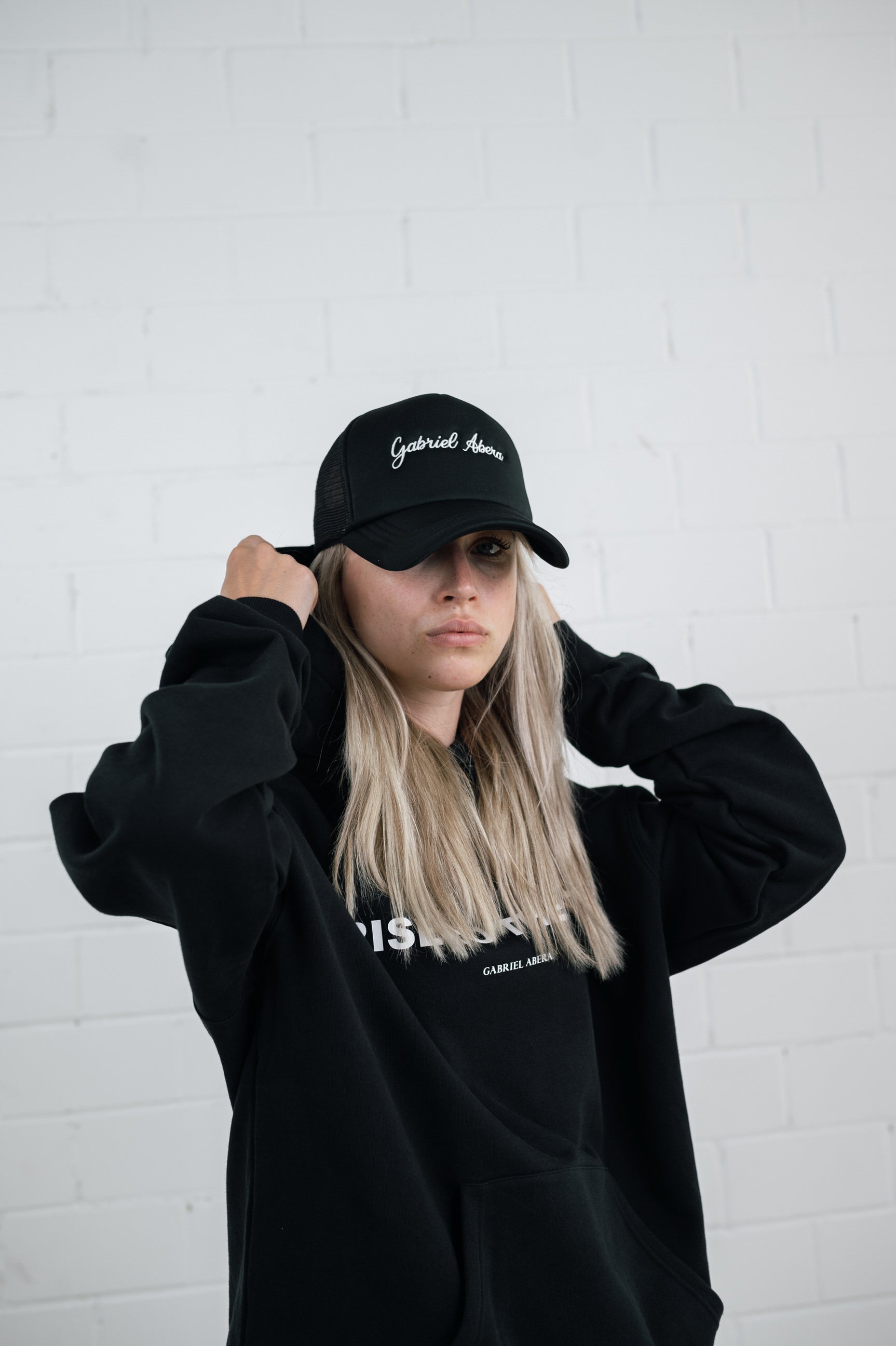 Female model wearing a Black foam cap with brand name embroidery
