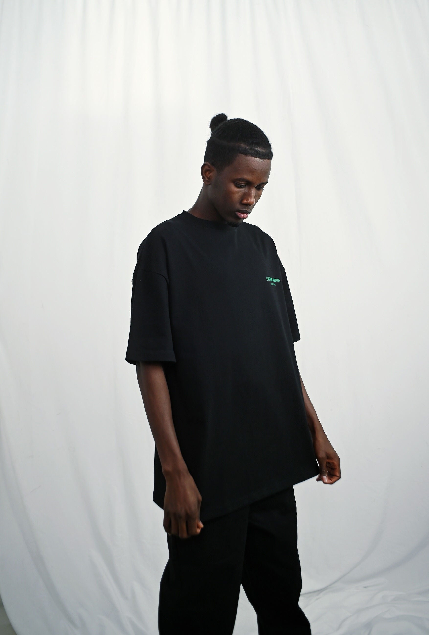 Male model wearing a Black oversize tshirt with green born to win design on the back